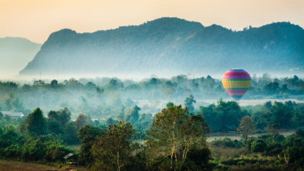 Take in the stunning Vang Vieng landscape from a hot air balloon at Laos.