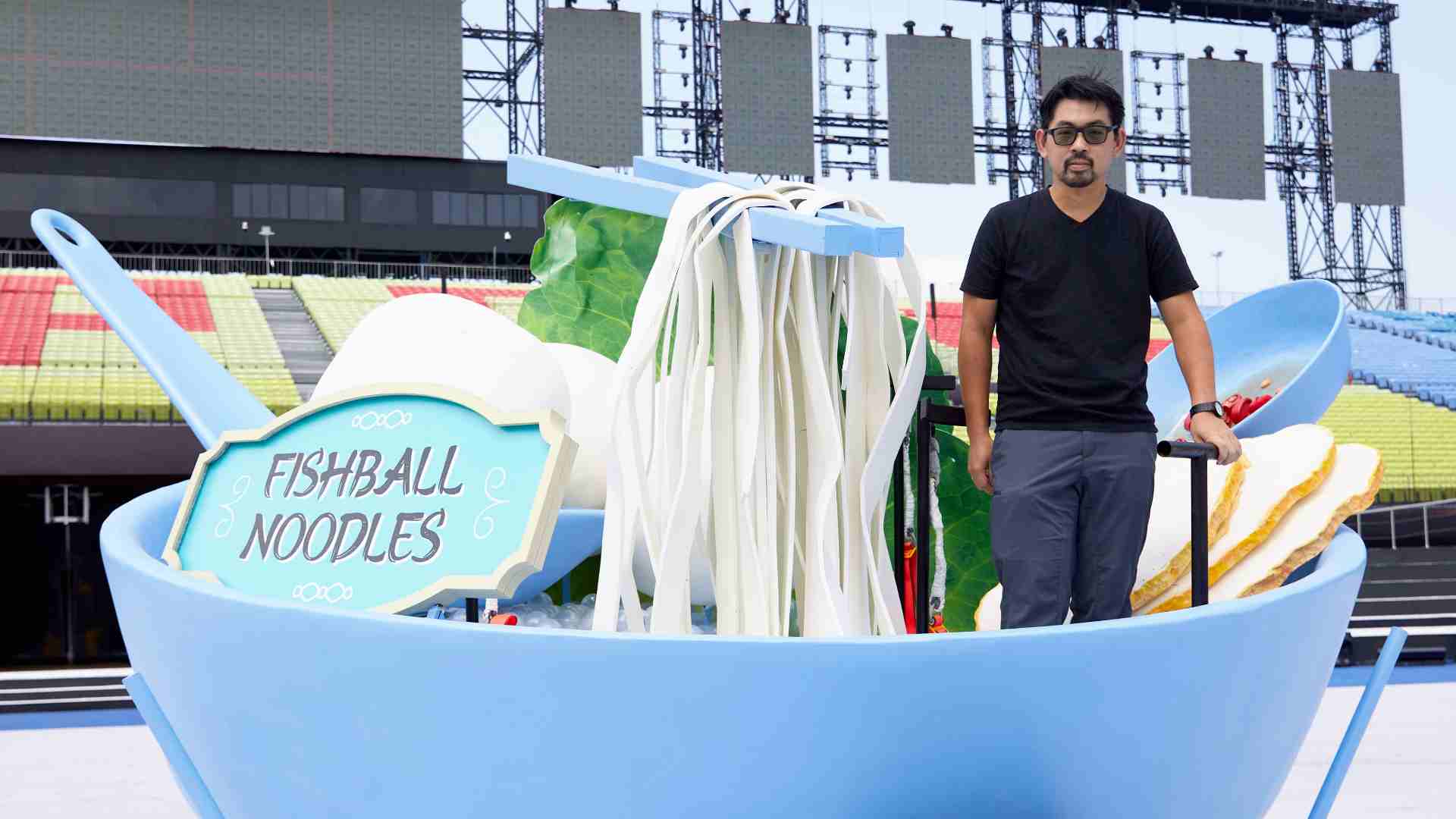NDP 2024 Large Props Designer Deric Shen in one of four giant food bowls that will glide across the Padang on 9 Aug.