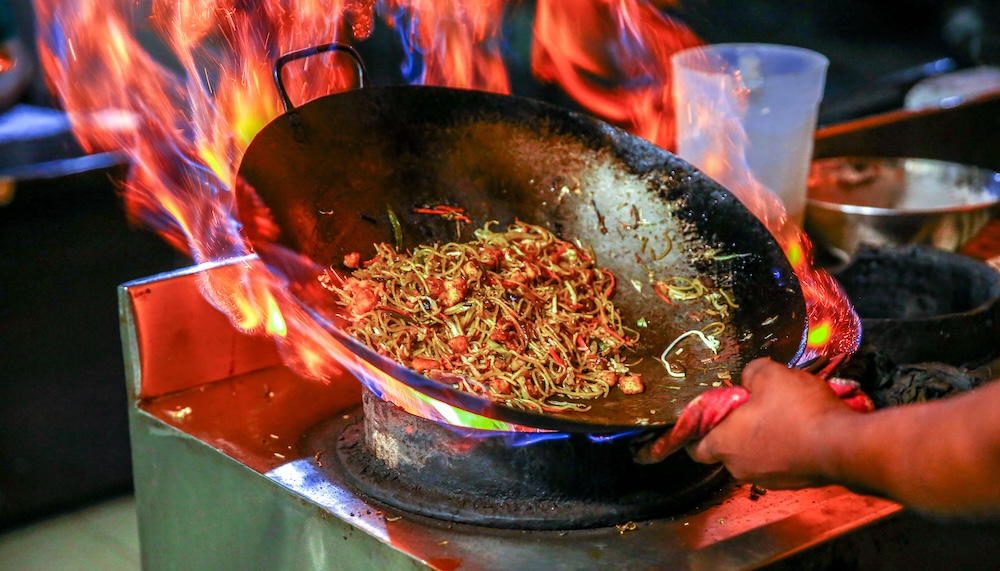 photo of someone cooking with a wok